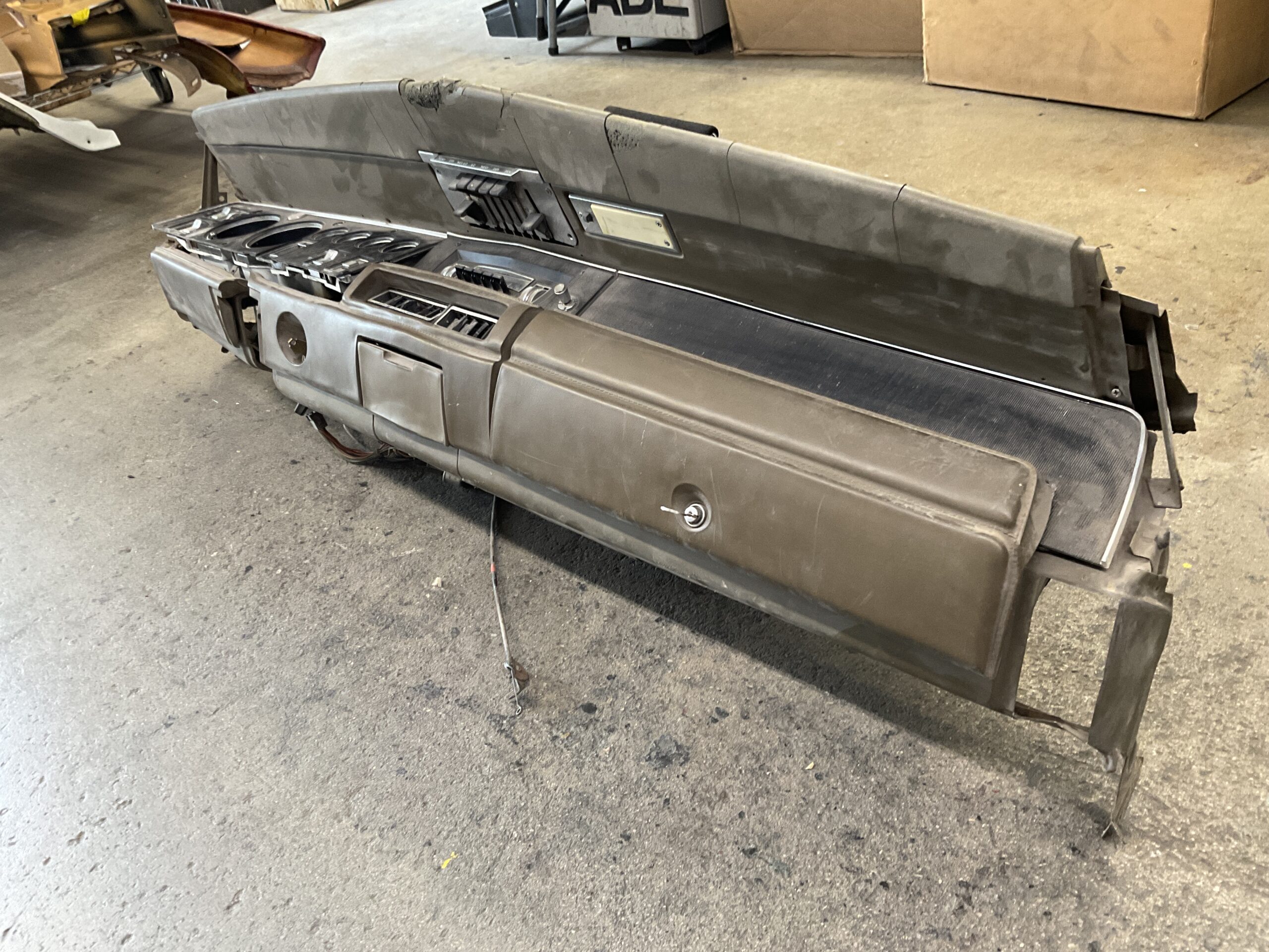 Damaged car dashboard with torn fabric.